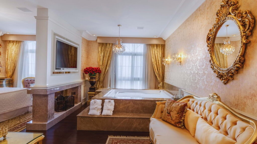 Banheira com decoração clássica e luz natural em suíte de luxo