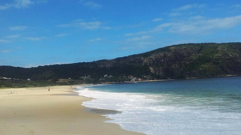 Praia de Camboinhas em Niterói, com mar calmo e areia clara.