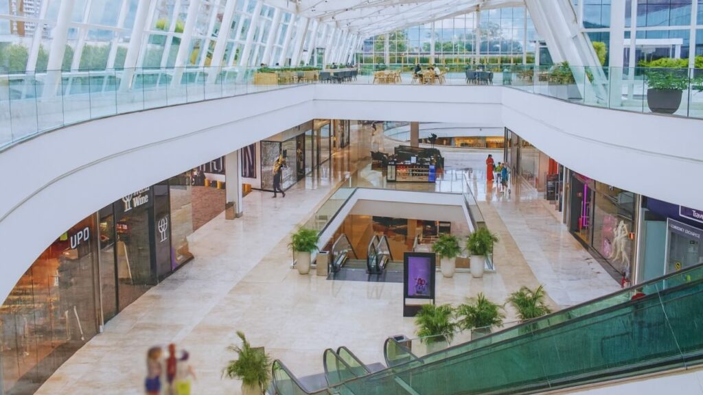 Interior do shopping Pátio Batel em Curitiba, com áreas de circulação amplas, lojas e luz natural entrando pelas janelas.