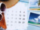 Imagem mostrando itens organizados para planejamento de viagem, incluindo calendário, passaporte, câmera, óculos de sol e fotos.