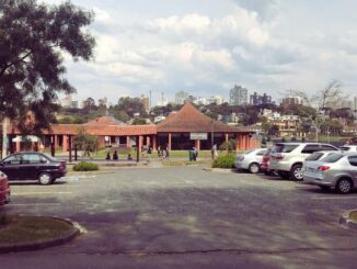 Área central do Parque Barigui com restaurantes e quiosques próximos às pistas e ao gramado.