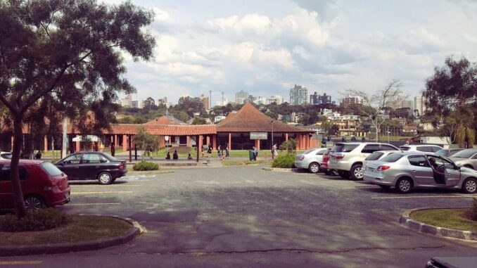 Área central do Parque Barigui com restaurantes e quiosques próximos às pistas e ao gramado.