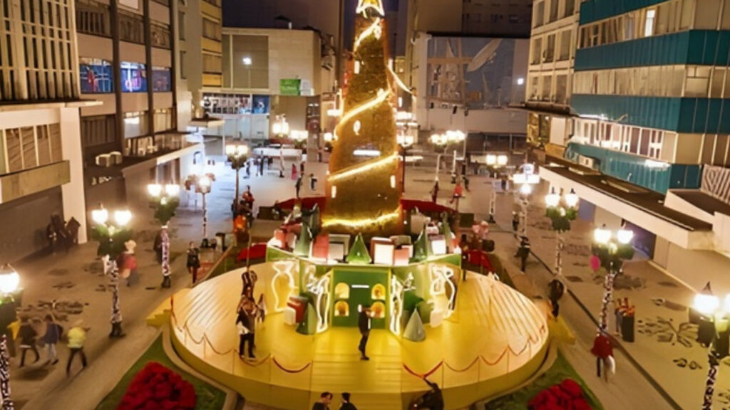 Decoração de Natal na Rua XV de Novembro, em Curitiba, com árvore iluminada, instalação temática e visitantes caminhando pela via exclusiva para pedestres.